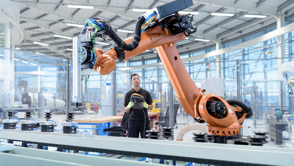 En robot- och automationsprogrammerare arbetar i en fabrik