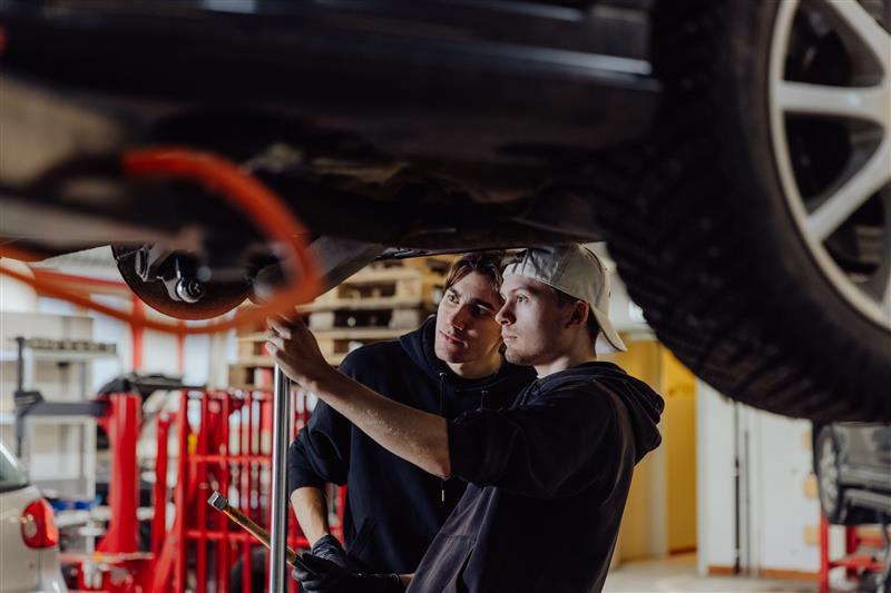 Två personer reparerar en bil